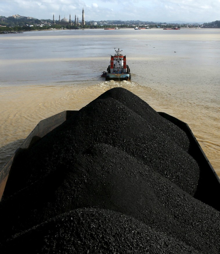 A tug boat pulls a coal barge along the Mahakam River in Samarinda